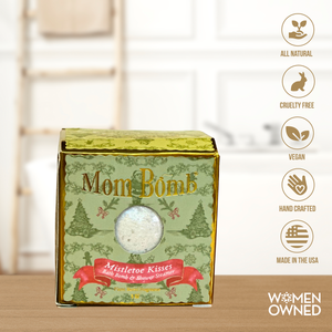 Mom Bomb Mistletoe Kisses Bath Bomb – green holiday gift box with gold accents, shown with icons for all natural, vegan, cruelty-free, handcrafted, and made in the USA