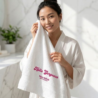 Model wrapped in the white Hello Gorgeous Turkish cotton bath towel with pink Mom Bomb embroidery